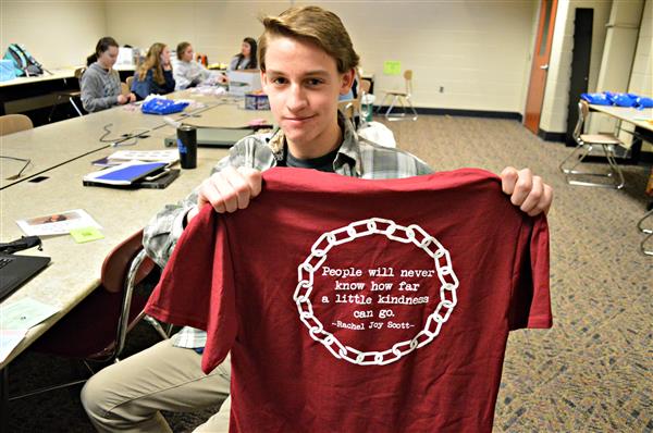 A Henderson High School student displays a kindness t-shirt for Kindness Week 